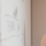 Red-haired lady standing in front of a whiteboard