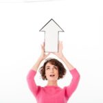 Woman holding an arrow pointing upwards